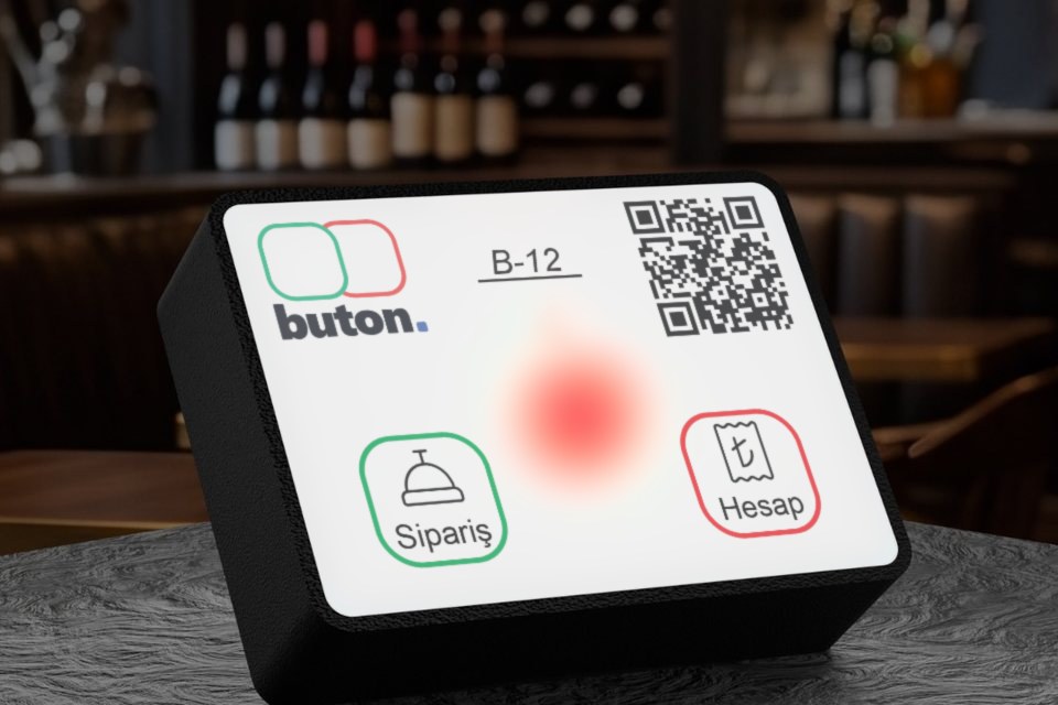 Kafe masasındaki Buton’un ön yüzünde kırmızı ışık yanıyor