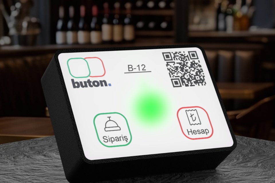 Kafe masasındaki Buton’un ön yüzünde yeşil ışık yanıyor